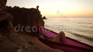 年轻的白种人躺在沙滩上的吊床上，欣赏着令人惊叹的<strong>金色</strong>日落美景。 1920x1080